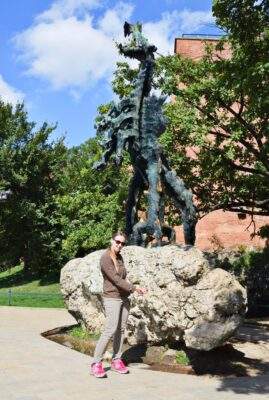 Travels-in-Poland-Diana in front of Wawel dragon in Krakow poland